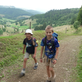Zwei Kinder wandern auf dem Westweg, umgeben von weiter Landschaft im Hintergrund.