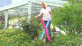 Edelgard Lechner blickt zufrieden in ihren blühenden Garten und betrachtet die Pflanzen.