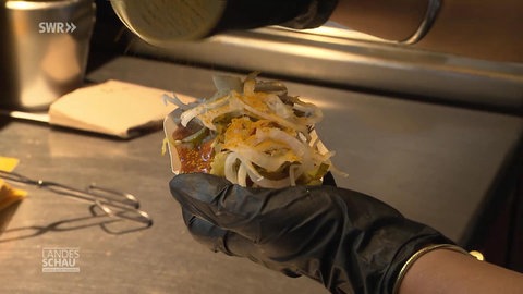 Eine Currywurst wird zubereitet