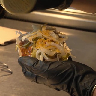 Eine Currywurst wird zubereitet