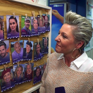 Schlagersängerin alexandra Hofmann übernimmt eine Rolle bei den Fallers. Sie steht vor einer Wand mit Autogrammkarten der Fallers-Schauspieler.