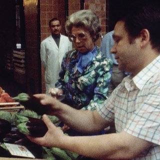 Gemüsemarkt 1979 - eine Frau kauft bei einem Gemüsehändler Auberginen.