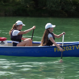 Kanutour auf dem Altrhein: zwei Frauen sitzen in einem blauen Kanu und paddeln.