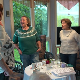 Frauen stehen in einem Wintergarten