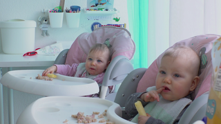 Zwei Babys schauen in die Kamera.