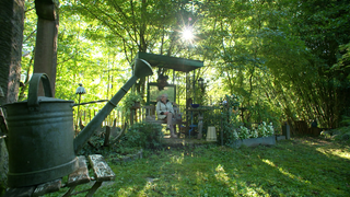 Henriette Brugger sitzt auf einer Bank in ihrem Garten.