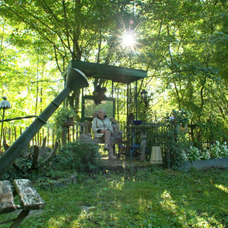 Henriette Brugger sitzt auf einer Bank in ihrem Garten.