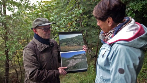 Armin Dieters zeigt Sonja Faber-Schrecklein Bilder vom Bergrutsch in Mössingen.