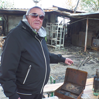 Harald Siedler steht vor den Ruinen seines abgebrannten Biergartens.