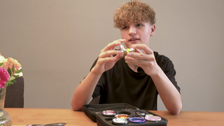 Yan Marosi sitzt an einem Tisch und zeigt ein Jo-Jo.