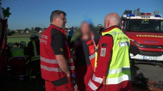 Heli-Retter im Einsatz: Notarzt Björn Hossfeld redet mit einem Rettungsteam 