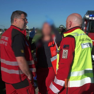 Heli-Retter im Einsatz: Notarzt Björn Hossfeld redet mit einem Rettungsteam 