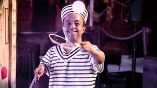 Hammou ist Seifenblasenkünstler. Er steht auf der Bühne und performt mit Seifenblasen.