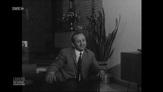 Ein Mann sitzt und lächelt