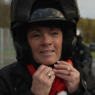 Sonja Faber-Schrecklein zieht sich einen Motoradhelm an