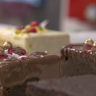 Eine junge Frau dekoriert selbstgemachte weihnachtliche Kuchen.