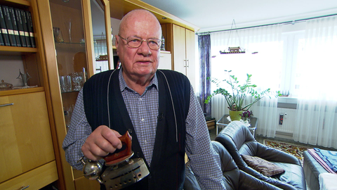 Klaus Karpinski hält eines seiner Bügeleisen in der Hand.