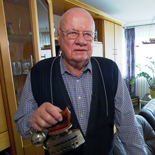 Klaus Karpinski hält eines seiner Bügeleisen in der Hand.
