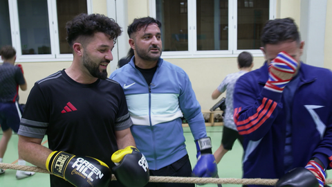 Luan steht mit seinen Boxkollegen im Studio, bereit für das Training mit Boxhandschuhen.