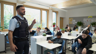 Der Comedy-Cop Luan spricht an einer Stuttgarter Schule zu Schülern.