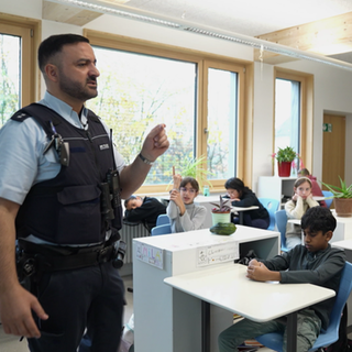 Der Comedy-Cop Luan spricht an einer Stuttgarter Schule zu Schülern.