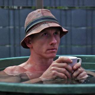 Ultraläufer Daniel Hernes sitzt in der Eistonne und hält eine Tasse in den Händen.