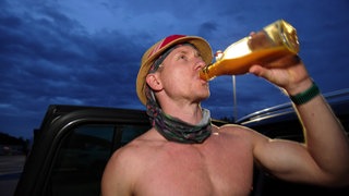 Ultraläufer Daniel Hernes aus Offenburg beim Training. Er trinkt aus einer Flasche und ist oberkörperfrei.