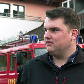 Philip Wenger steht vor einem Feuerwehrauto, das er ersteigert hat.