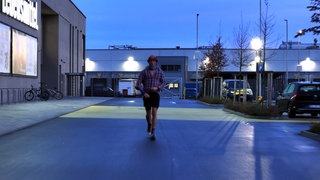 Daniel Hernes läuft einen Ultramarathon auf einem Parkplatz.