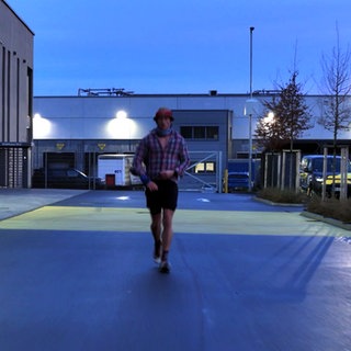 Daniel Hernes läuft einen Ultramarathon auf einem Parkplatz.