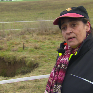 Adriana Schulz-Stubenrauch steht vor den Dolinen (kreisrunde Löcher), die sich auf ihrem Pferdeschutzhof in Ravenstein im Neckar-Odenwald-Kreis aufgetan haben.