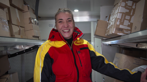 Nadine befüllt ihren Lieferwagen mit Paketen.