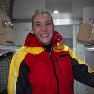 Nadine befüllt ihren Lieferwagen mit Paketen.