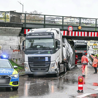 Ein Lastwagen steckt in der Bahnunterführung der B290 in Jagstzell fest, während ein Polizeiauto die Engstelle absichert.