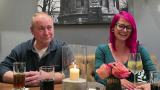 Schornsteinfegerin Moana sitzt an einem Tisch und lacht.