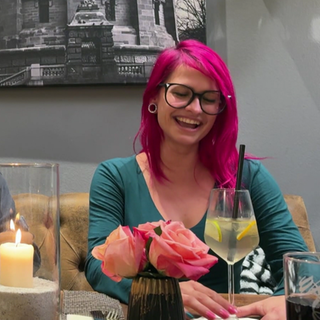 Schornsteinfegerin Moana sitzt an einem Tisch und lacht.