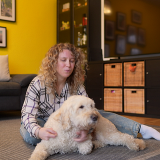 Lisa Mümmler umarmt ihren Assistenzhund Harry, ein Golden Doodle, liebevoll in einem vertrauten Moment.