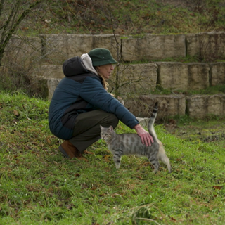 Ein Mann geht mit einer Katze spazieren