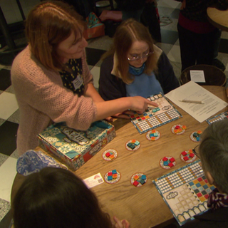 Menschen spielen beim Playdate in Freiburg ein Brettspiel