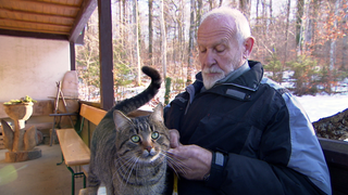 Eine Katze sind auf dem Schoss eines Besuchers im Friedwald Münsingen