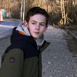 Christian aus Kirchheim will die stillgelegte Bahnstrecke reaktivieren. Er trägt eine WInterjacke und steht neben den Bahngleisen.