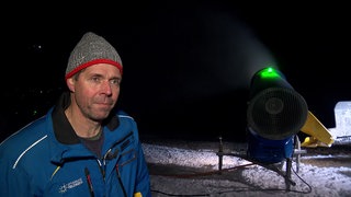 Matthias Schneider steht nachts neben einer Schneekanone. Gemeinsam mit seiner Schwester betreibt er Skilifte in Todtnauberg.