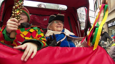 Luitgard Ehmsen ist die Protektorin der Lörracher Fastnacht. Die 88-Jährige sitzt mit einem Jungen in einer Rikscha.