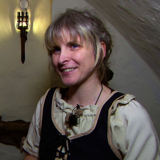 Lisa Hofmann hat in Ludwigsburg eine Fantasy-Taverne eröffnet. Sie trägt ein Kleid wie im MIttelalter und steht in ihrer Kneipe.