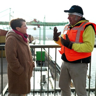 Sonja Faber-Schrecklein redet mit dem Pressesprecher des Stuttgarter Hafens, Johannes Zeller. Im Hintergrund sieht man den Neckar und Container.