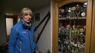 Skiliftbetreiberin Andrea Brenders aus Todtnau steht neben einer Vitrine mit Pokalen, Sie trägt eine blaue Fleecejacke.