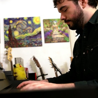 Steve Castile spielt Klavier. Im Hintergrund sind Gitarren zu sehen.