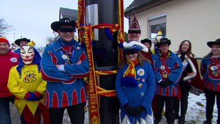 Die Fasnetgruppe Haugga Narra steht an einem Blitzer in Essingen. Um den Blitzer sind Schals geknotet.