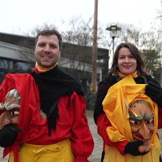 Ein Mann und eine Frau mit ihren Hexenmasken und Kostümen