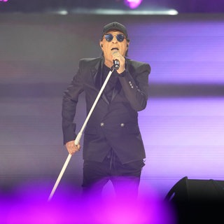 Sänger Peter Schilling singt bei einem Konzert in Frankfurt. Er trägt eine schwarze Kappe und einen schwarzen Anzug.